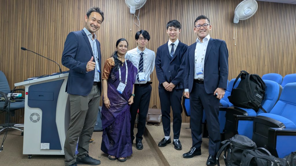 発表後の集合写真です。
左から、サムズアップしている加藤先生、発表の司会をしてくださったインドの方、修士の平野と千野、そして博士課程の栗原さんが写っています。